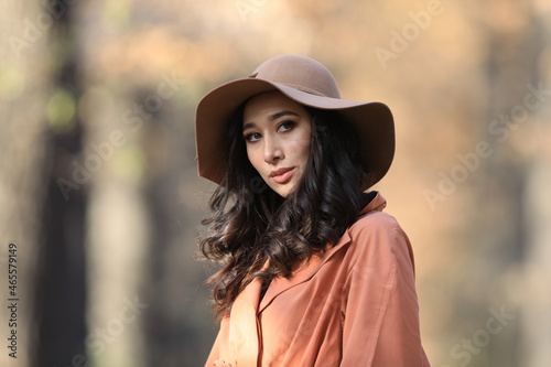 autumn portrait of a beautiful asian brunette woman in a fashionable hat © serikbaib
