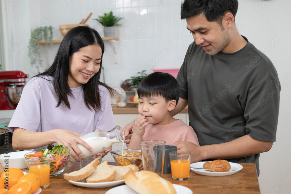 happy family together. Asian parent eating breakfast with little son in the kitchen. happy family together. Asian parent eating breakfast with little son in the kitchen.