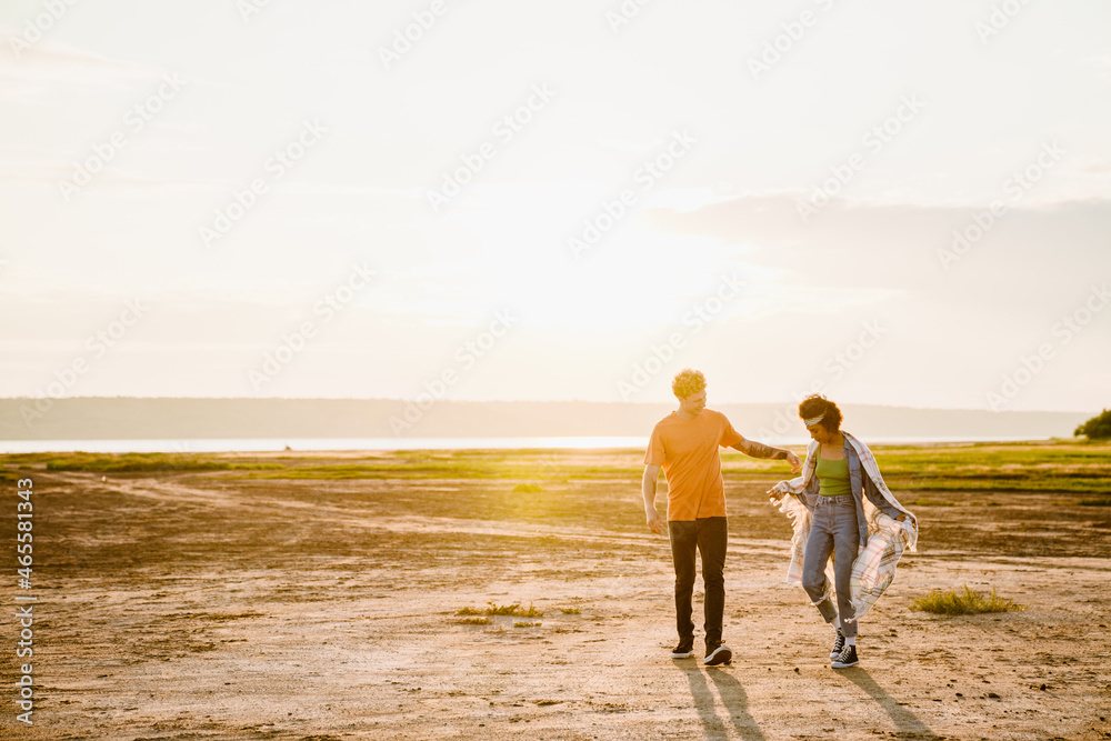 Young multiracial couple smiling while walking together