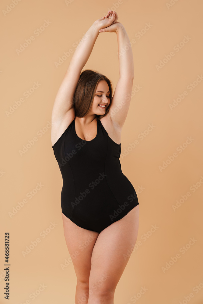 Obraz premium Young woman wearing swimsuit smiling while posing on camera