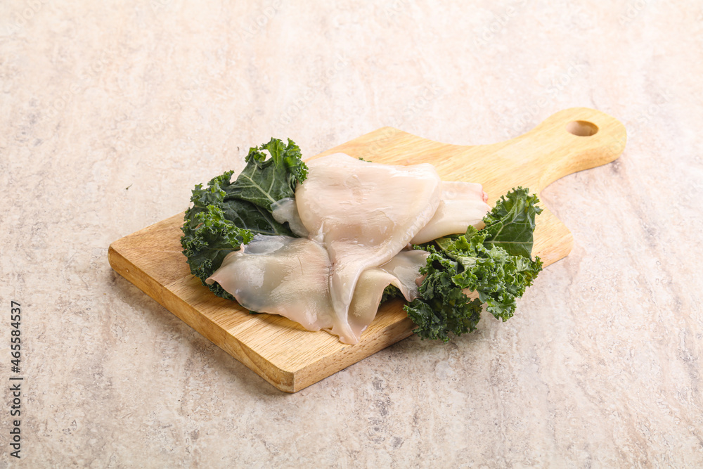 Raw squid over wooden board