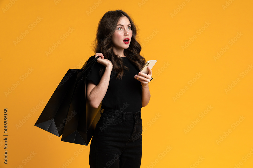 White shocked woman posing with shopping bags and cellphone White shocked woman posing with shopping bags and cellphone