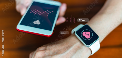 Close-up of a smart watch health tracker with the heart rate shown on the watch and smartphone screens. Modern stylish and innovation wearable device