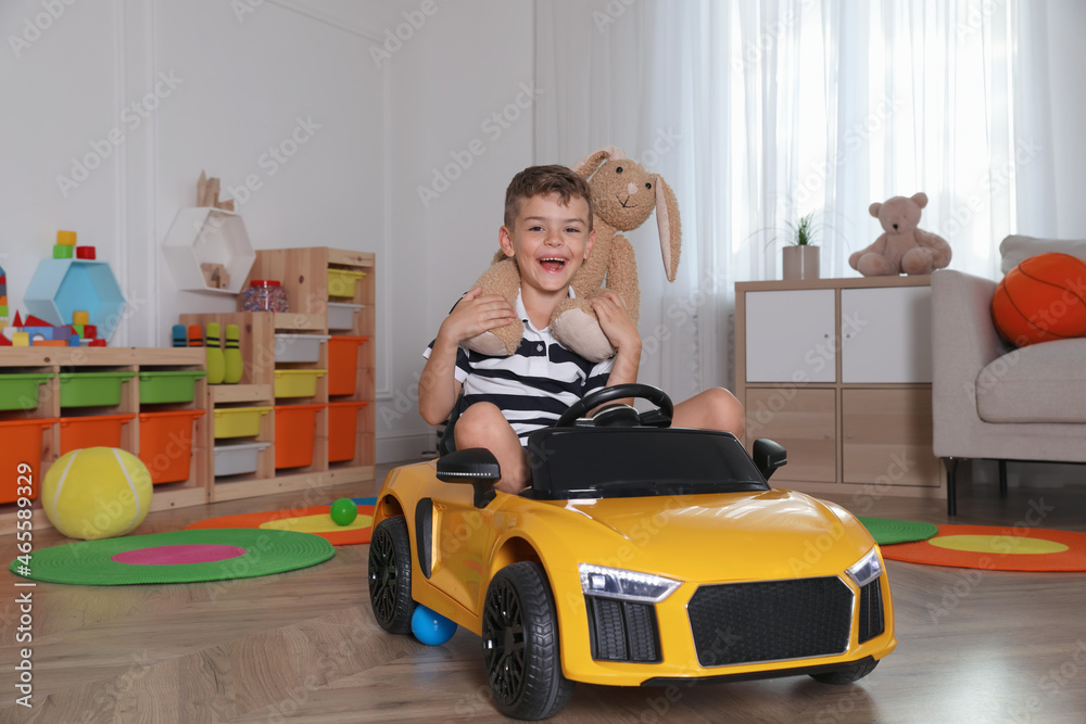 Cute little boy driving big toy car at home Cute little boy driving big toy car at home