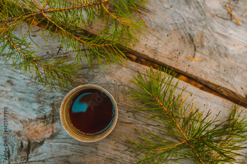 Mug with Coffee, Top View, on a Wooden Background Among the Christmas Tree Branches. Tea on the Table in the Park. Picnic in the Nature. Coffee Concept Photo.