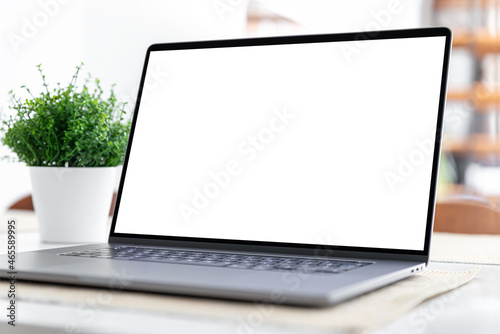 Laptop with blank screen on table in home interior © guteksk7