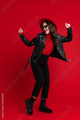 White woman in leather jacket laughing while dancing on camera © Drobot Dean