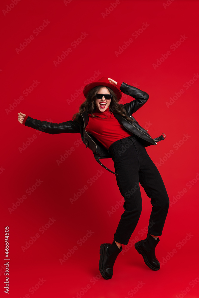 White woman in leather jacket laughing while dancing on camera