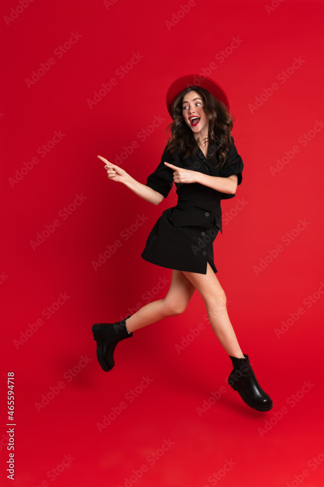 White woman wearing dress pointing fingers aside while running