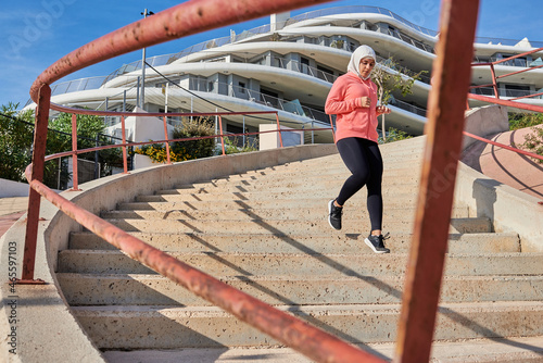 Muslim young woman wears a hijab while running