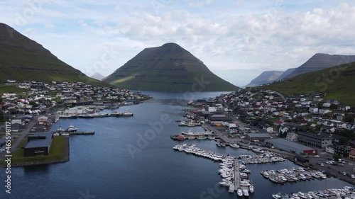 Beautiful Cinematic aerial footage of the City of Klaksvik in the Fareo Islands with its colorful houses and amazing canal and view of the majestic Kunoy Park