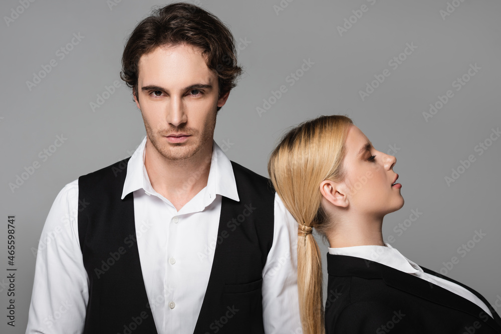 blonde woman leaning on shoulder of elegant man looking at camera isolated on grey blonde woman leaning on shoulder of elegant man looking at camera isolated on grey
