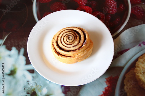 Appetizing cinnamon roll on a white plate