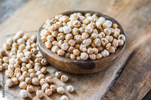 Raw chickpeas in a wooden bowl. Legume dietary fibers and vegetable protein for healthy eating.