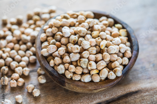 Raw chickpeas in a wooden bowl. Legume dietary fibers and vegetable protein for healthy eating.