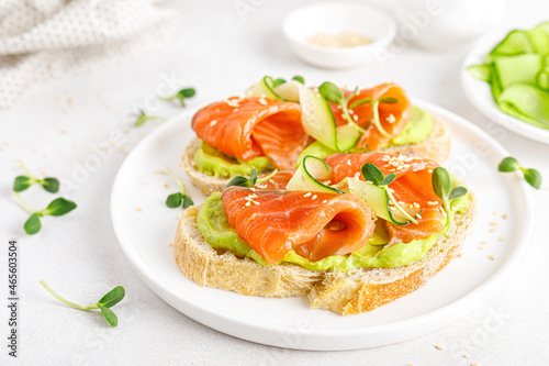 Open sandwiches with salted salmon, guacamole avocado and microgreens. Seafood. Healthy food.