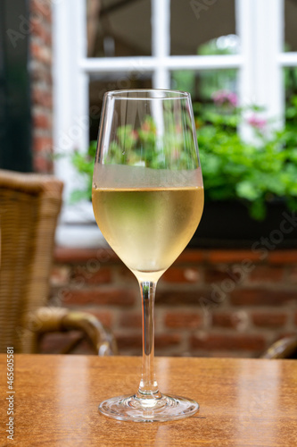 Glass of cold white wine served on outdoor terrace in old French cafe