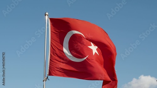 A large turkish flag or flag of Turkey waving against blue sky during sunny summer morning in Istanbul, Turkey	