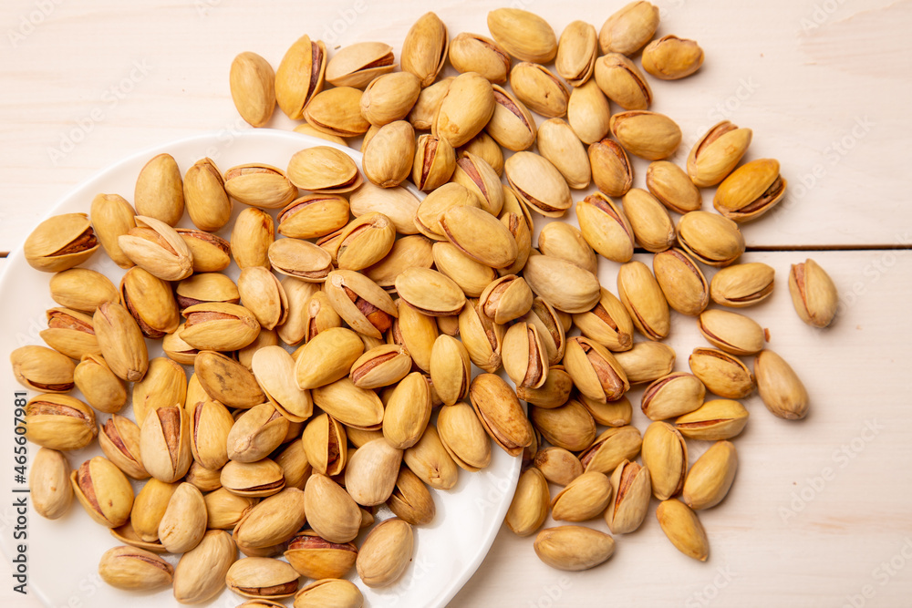 Pistachio nuts in a shell with salt on a background of white boards. Beer appetizer - salted nuts. concept is snacks for beer. Pistachio nuts in a shell with salt on a background of white boards. Beer appetizer - salted nuts. concept is snacks for beer.
