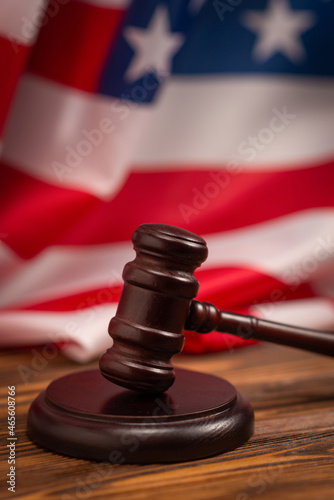 Wooden judge gavel and soundboard on american flag background.