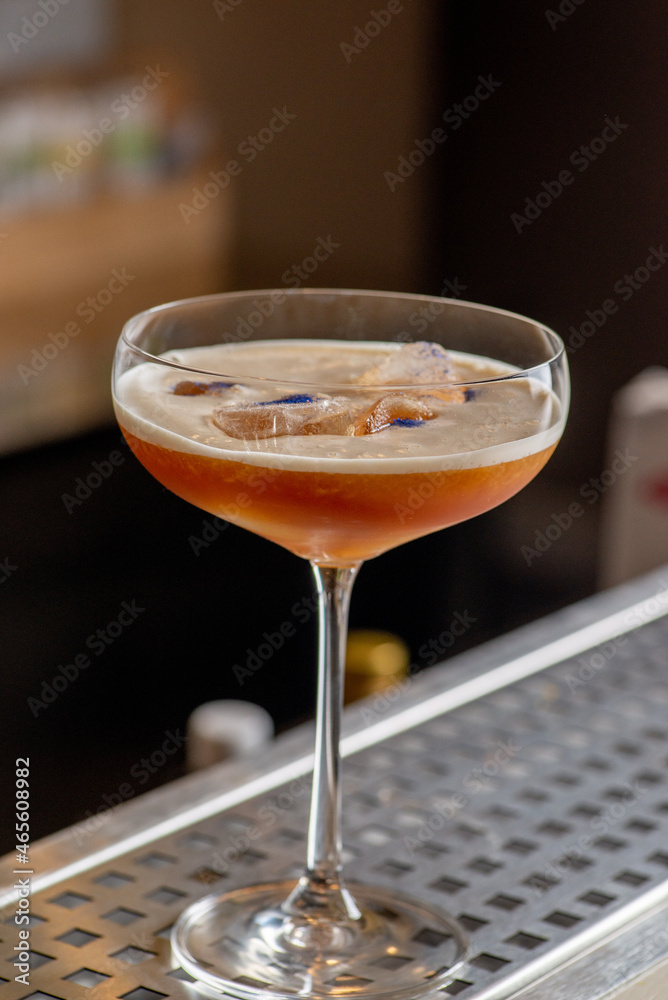 Ready orange cocktail with glitter foam on the bar