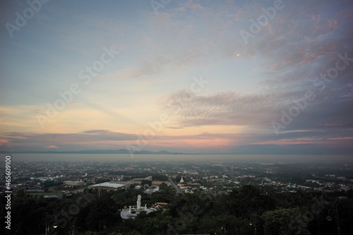 Aerial view of citscape from the top of mountain covered by the fog with horizontal line of mountain in background with sunrise in the morning