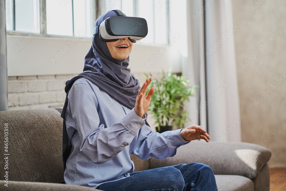 Astonished Muslim woman using a VR headset for the first time