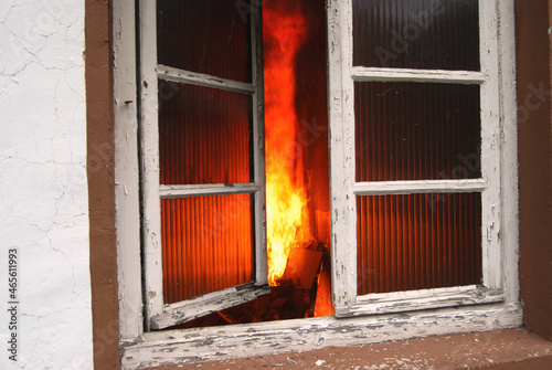Blick durch ein Fenster in eine brennende Wohnung photo