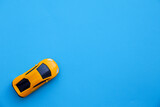 Yellow car on a blue background. Background for designers, automotive concept. Copy space