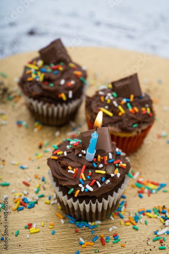 Chocolate cupcake with a golden plate with crumbs and a candle with sprinkles