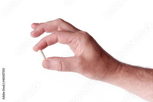 male hand isolated on white background holding a pill