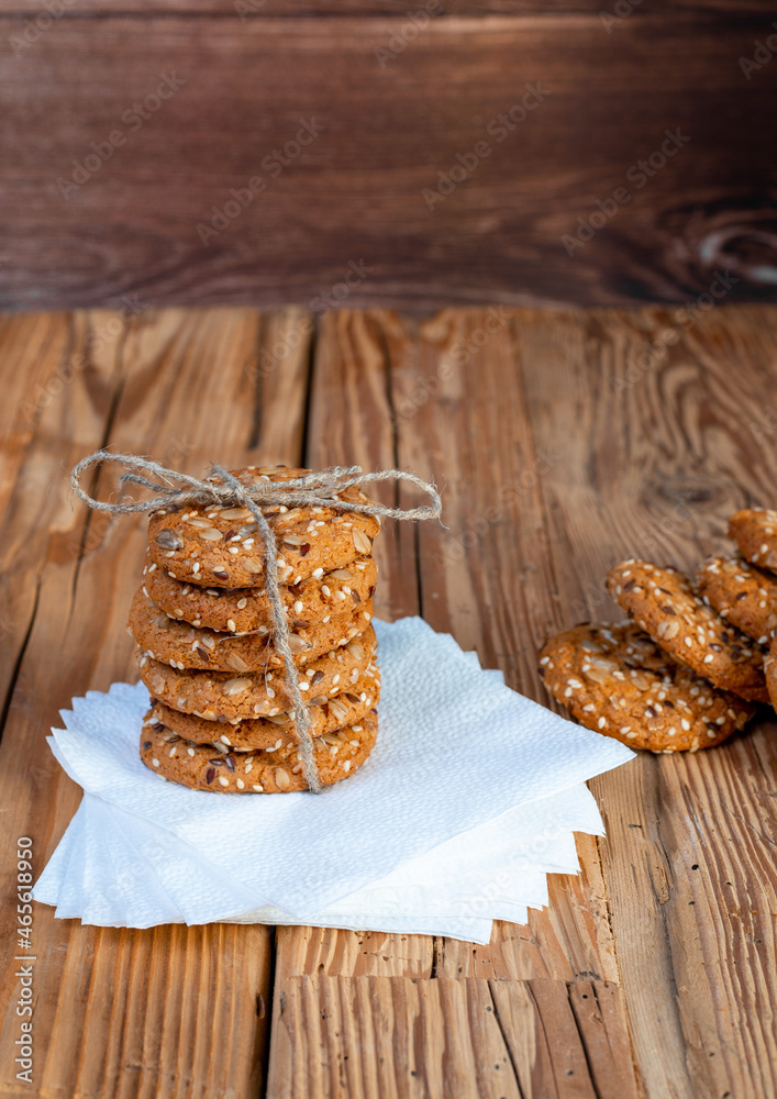Fototapeta premium Homemade cookies with seed pieces, laid out in a stack on the stem on a tree table.