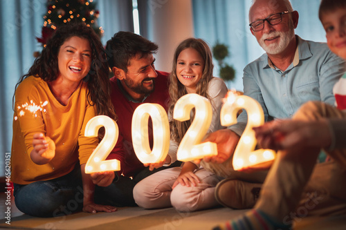 Family holding illuminative numbers 2022 while celebrating New Year photo