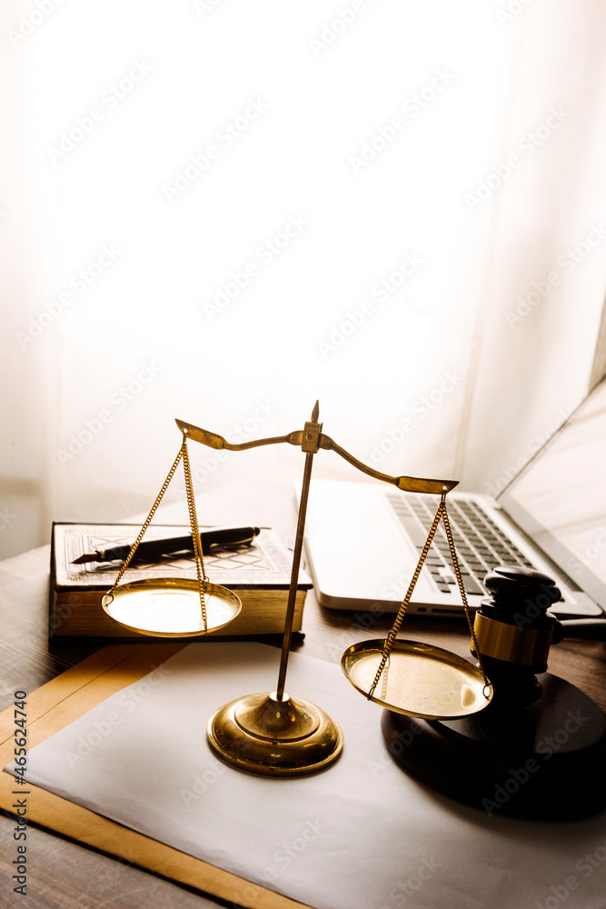 Justice and law concept.Male judge in a courtroom with the gavel, working with, computer and docking keyboard, eyeglasses, on table in morning light