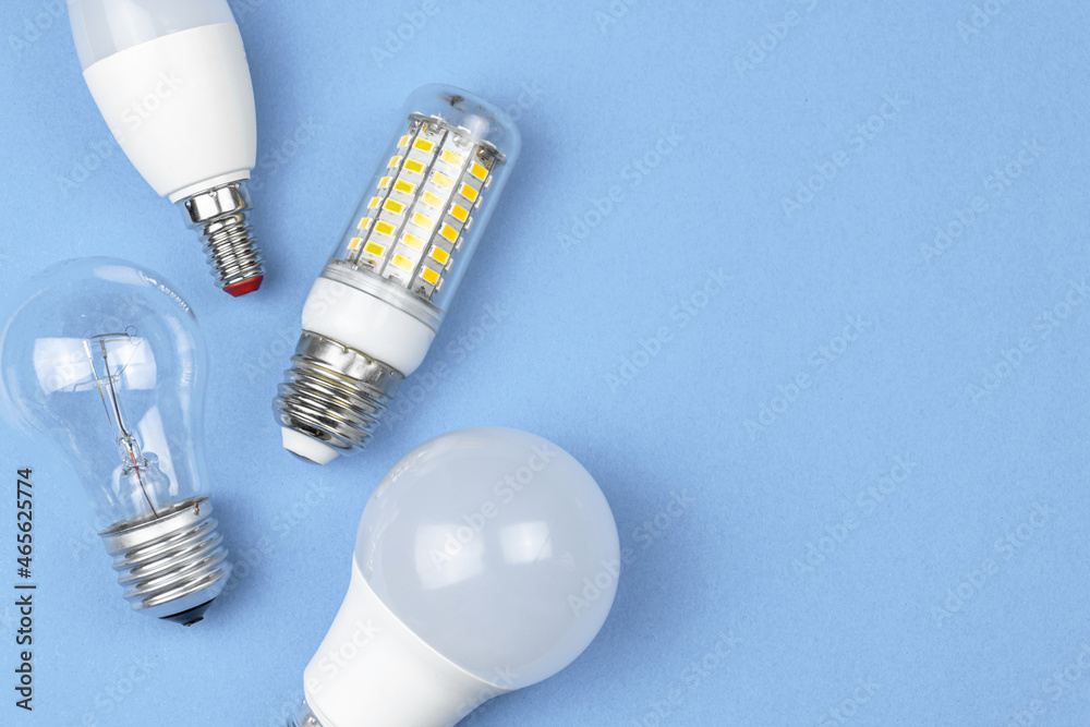 Old and new bulbs together, pastel blue background. Energy saving concept. Flat lay, top view photo Old and new bulbs together, pastel blue background. Energy saving concept. Flat lay, top view photo
