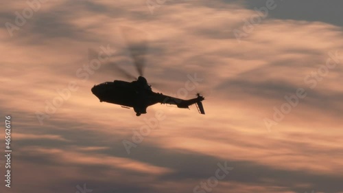 Military helicopter flying at sunset