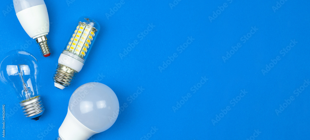 New and old LED light bulbs together, blue background. Energy saving concept. Banner, flat lay, top view photo New and old LED light bulbs together, blue background. Energy saving concept. Banner, flat lay, top view photo