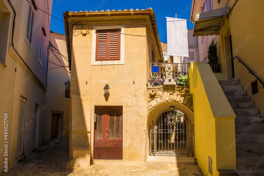 Fototapeta premium Houses in a quiet residential street in the historic medieval centre of Krk Town on Krk Island in the Primorje-Gorski Kotar County of western Croatia