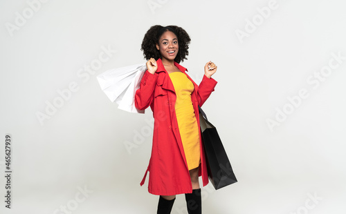 Young black woman smiling while posing with shopping bags