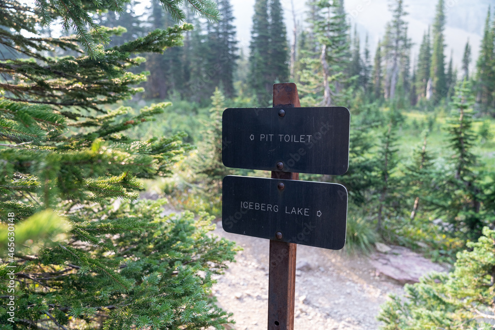 Sign for the pit toilet along the Iceberg Lake trail in Glacier National Park Sign for the pit toilet along the Iceberg Lake trail in Glacier National Park