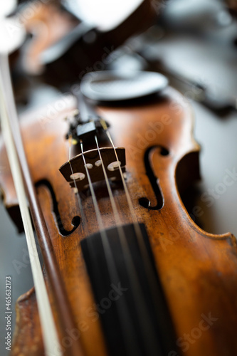 A shallow depth of field shot of a violin or a viola which is a string instrument that is common to a classical orchestra