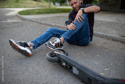 A man who fell from an electric scooter and is holding his knee