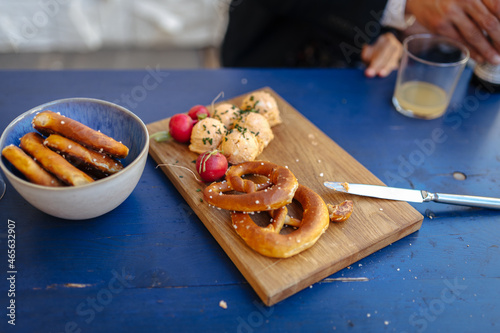 Bavarian pretzels and traditional Bavarian cheese delicacy Obatzda on a wooden cutting board garnished with radishes.  photo