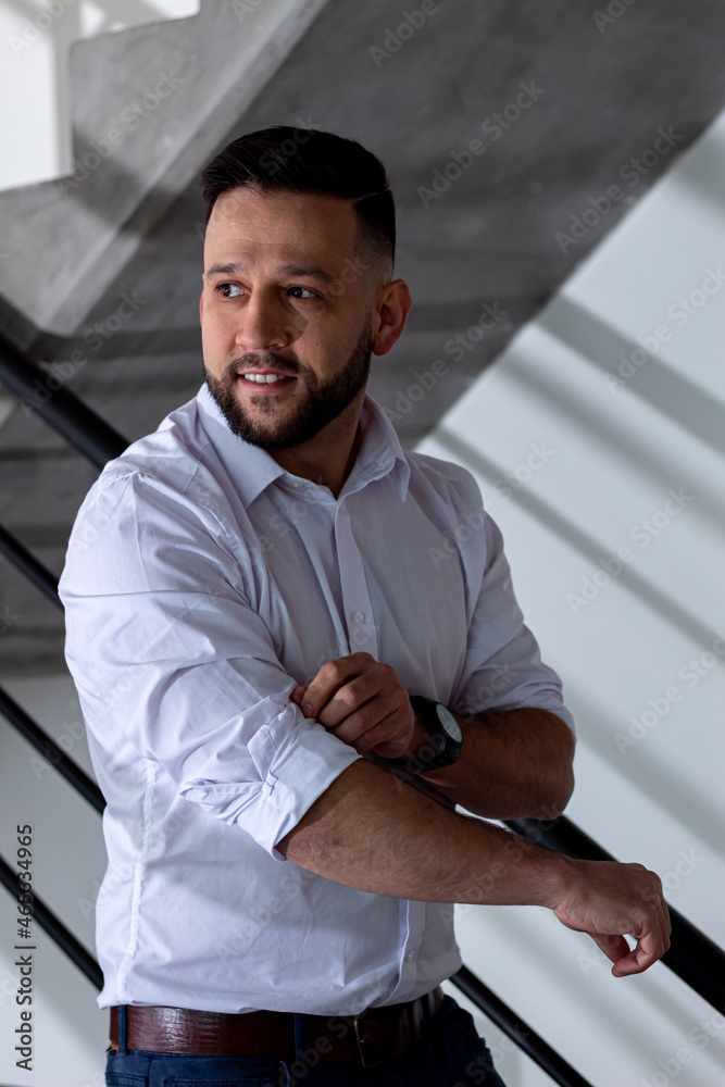 Obraz premium fashionable man posing in trendy apartment in a white button down shirt