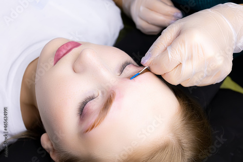 close-up of the eyebrows the master gives shape with a brush after the procedure long-term styling and lamination of the eyebrows