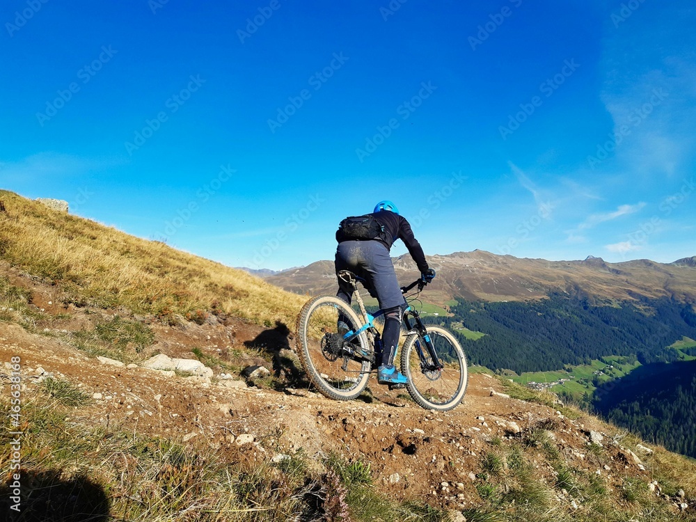 Enduro ride with steep bend, banked curve, Swiss Mountain Alps at Davos Switzerland. With blue clear sky and great view