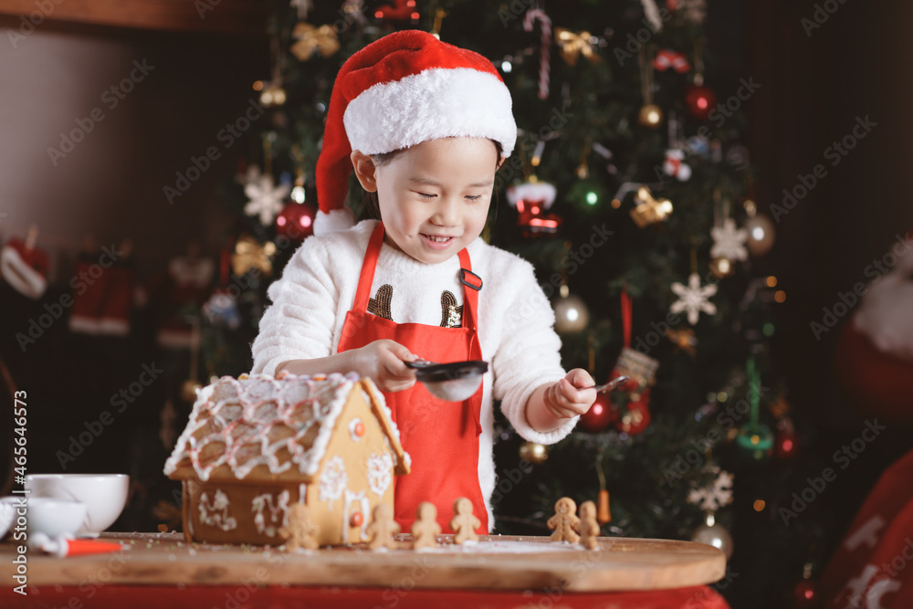 young girl making gingerbread house at home