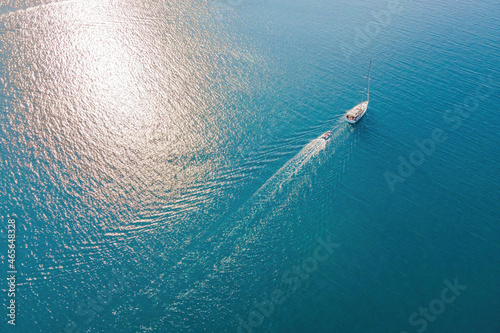 Sailboat in the sea. White sailing yacht in the middle of the boundless ocean. Aerial view. © Leonid