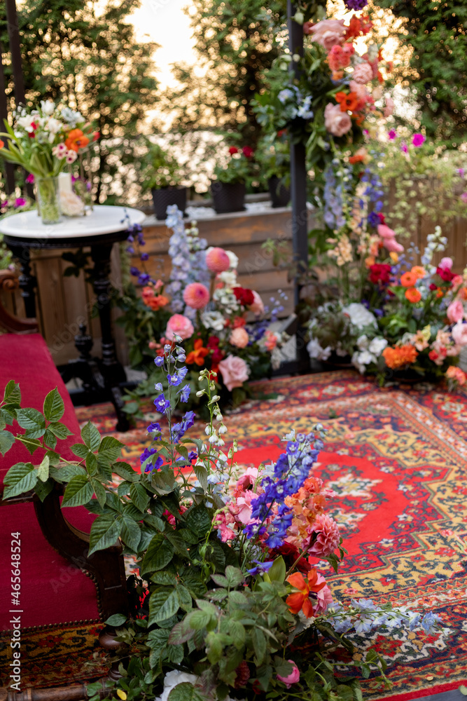 decoration of a fotozone with natural flowers, eastern carpet and sofa