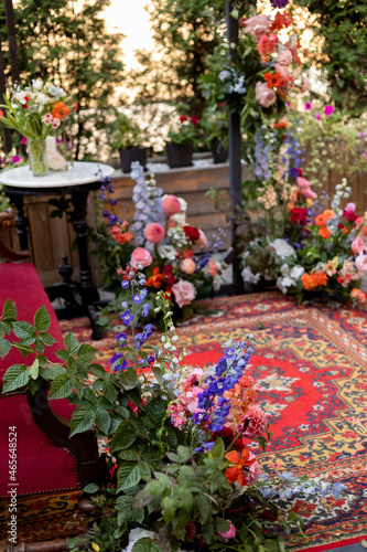 decoration of a fotozone with natural flowers  eastern carpet and sofa